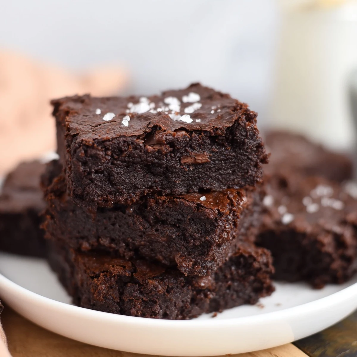 A square serving of Homemade Dark Chocolate and Sea Salt Brownies, ready to be enjoyed with vanilla ice cream.