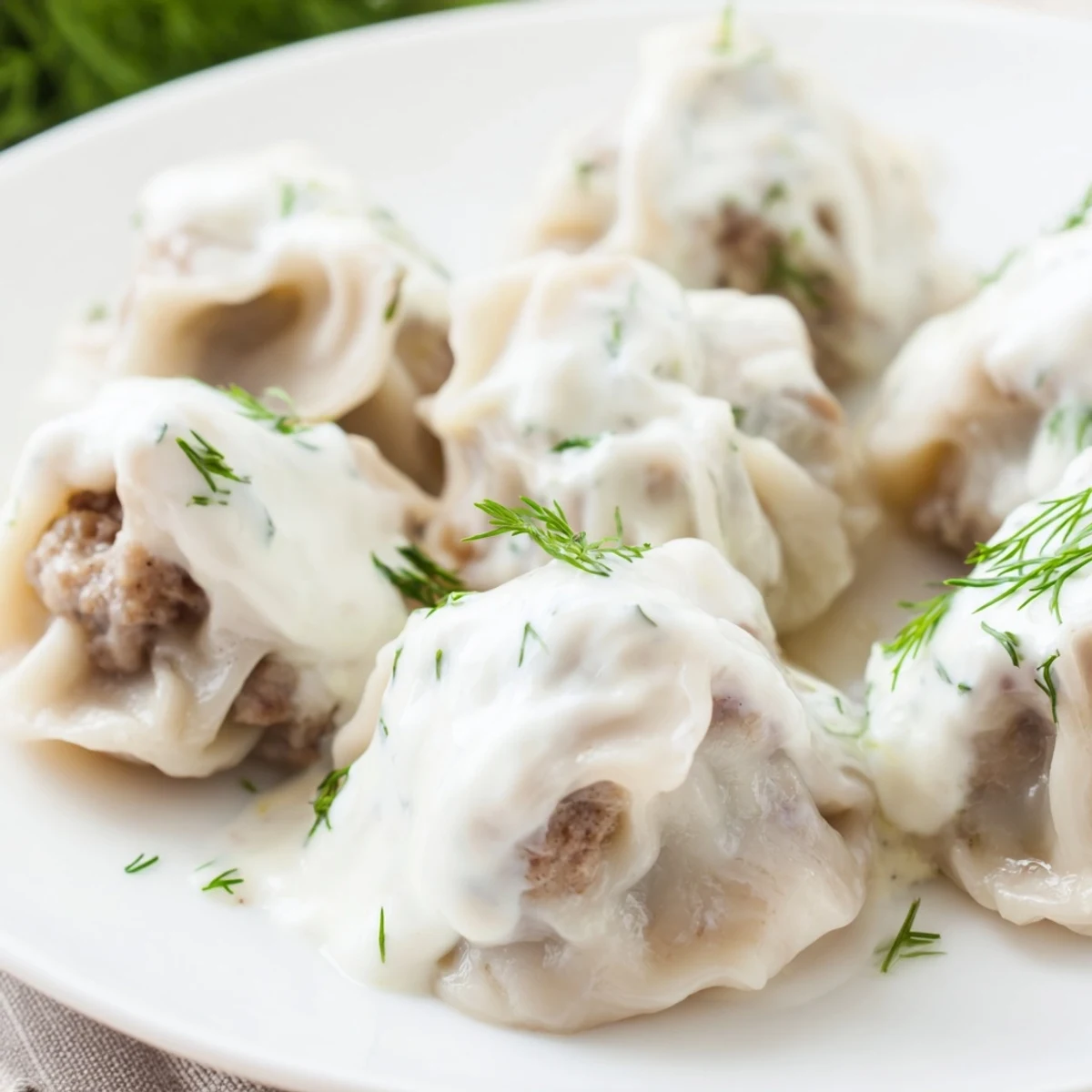 Steaming Russian pelmeni, perfectly formed dumplings, ready to be enjoyed with creamy sour cream.
