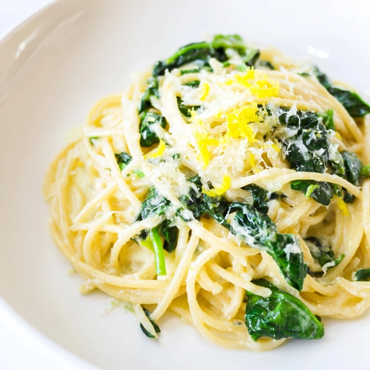 A skillet of Creamy Lemon Spinach Spaghetti, tossed with silky sauce, spinach, and a squeeze of fresh lemon.