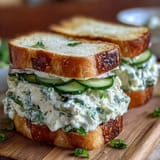 Delicate Mothers Day tea party sandwiches with lemon butter, cucumber, and fresh herbs, arranged on a vintage platter.