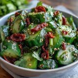 Garlic chili oil drizzled over smashed cucumber salad, bursting with bold, spicy flavors.
