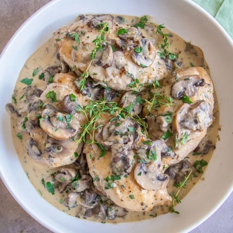 Golden-brown skillet-seared chicken breast paired with a luxurious mushroom cream sauce, perfect for a special meal.