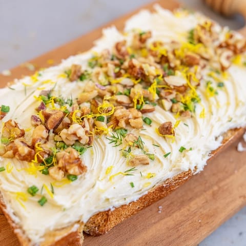 Beautiful Butter Board Charcuterie appetizer with vibrant toppings, perfect for dipping crusty bread in.