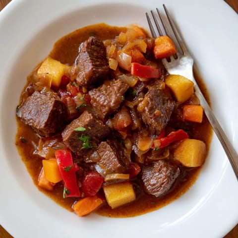 A steaming bowl of Hungarian Goulash Stew with tender beef and vegetables, ready to serve and enjoy.