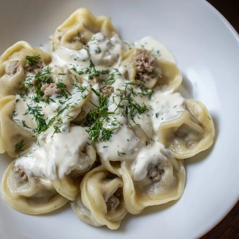 Hot and savory Russian pelmeni bursting with seasoned meat, a comforting winter dinner.