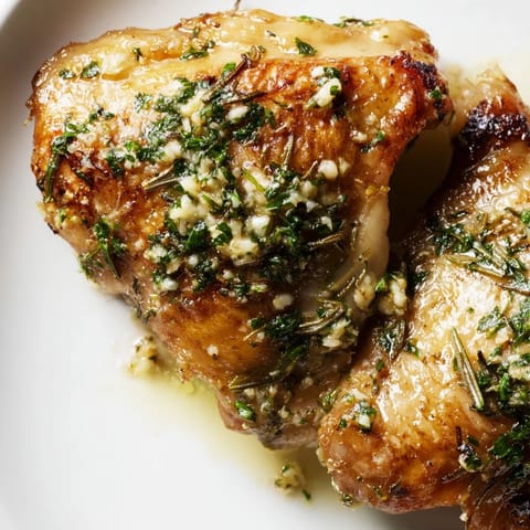 Juicy Garlic Butter Chicken Thighs plated with lemon wedges and parsley, ready to serve for dinner.
