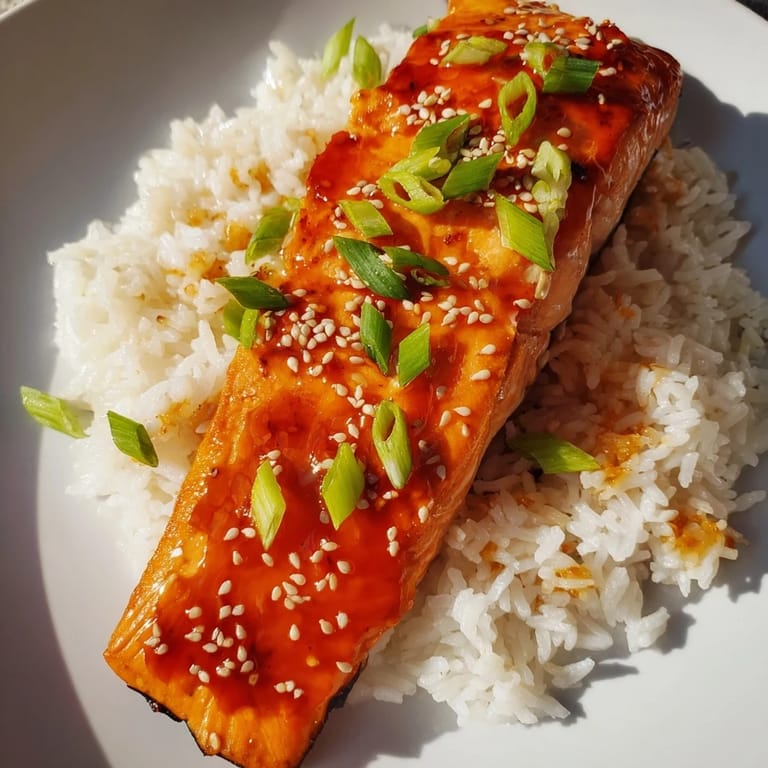 A close-up shot of the Sticky Orange Salmon with Rice, showcasing the flaky salmon and sweet glaze.