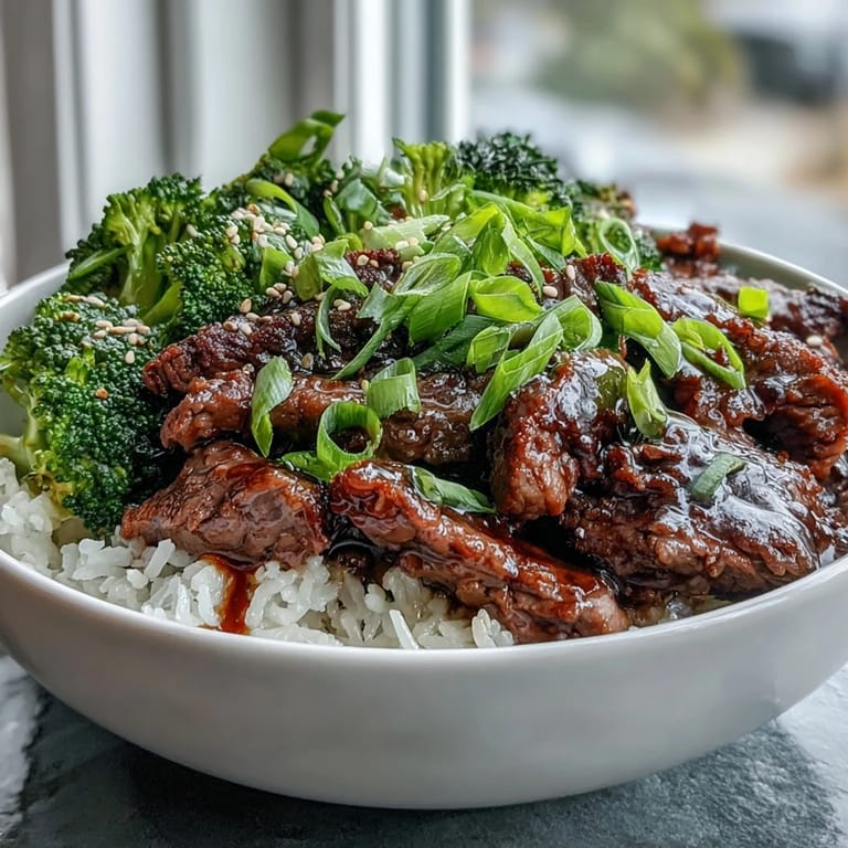 Sizzling tender beef strips are tossed in a glossy soy-ginger sauce for this Beef and Broccoli Bowl, ready for a quick weeknight dinner.
